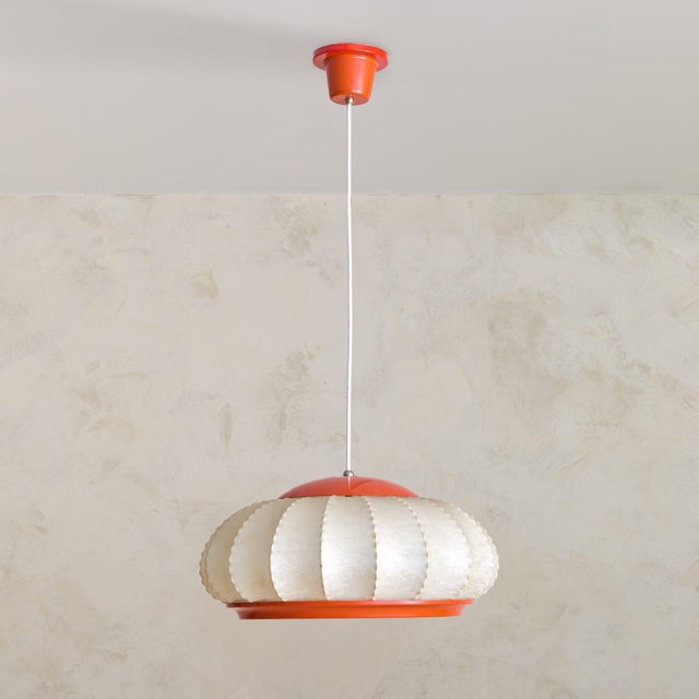 An Italian cocoon pendant from the 1960s. Suspended from a slender stem, the fixture is constructed around a metal frame...