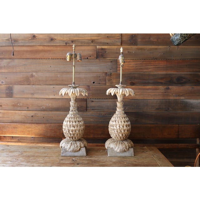 A sculptural and highly decorative pair of vintage Italian carved wood pineapple table lamps, celebrating the classic...