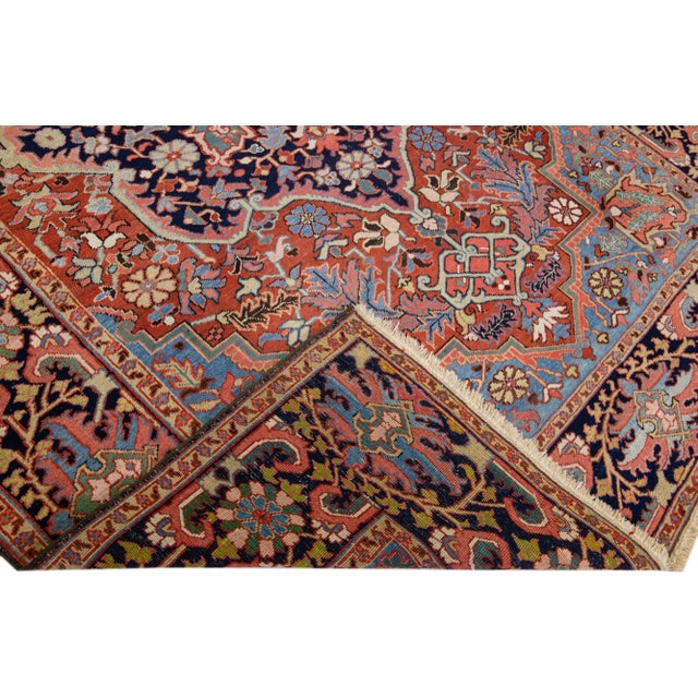 Beautiful antique Heriz hand-knotted wool rug with a rust color field. This Persian rug has multicolor accents in a...
