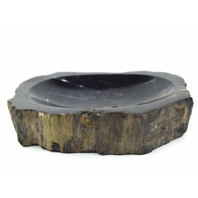 This striking, handcrafted natural stone bowl presents a dramatic contrast, featuring a highly polished, deep black...