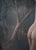 The artwork depicts an intimate moment between two figures, embraced in a lush, shadowy forest setting. The soft, muted...