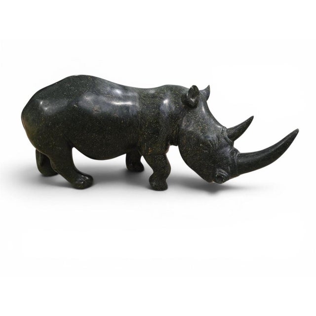 Exceptional hand-carved rhinoceros sculpture executed in serpentine stone by the Zimbabwean artist Lamelik, created during...
