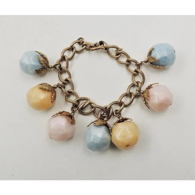 This is part of Chairish’s Costume Jewelry assortment. 1950s goldtone pastel blue, orange and pink resin dangles charm...