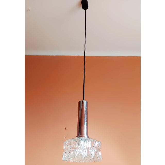 Vintage German space-age style pendant light, circa 1970/1980. The pendant consists of a round, molded glass shade with a...