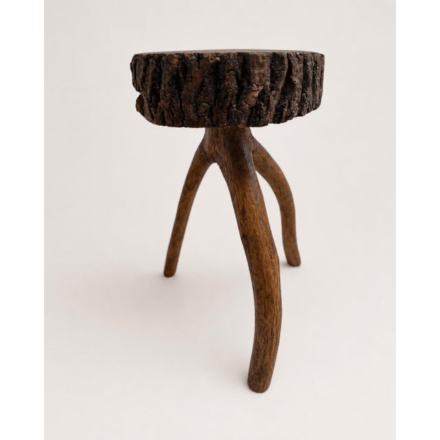 An exceptional example of organic Brutalist design, this vintage three-legged stool is crafted entirely from solid oak....