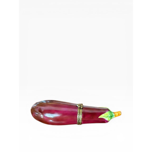 A finely detailed hand-painted Limoges porcelain trinket box, crafted in France and modeled in the form of a richly...