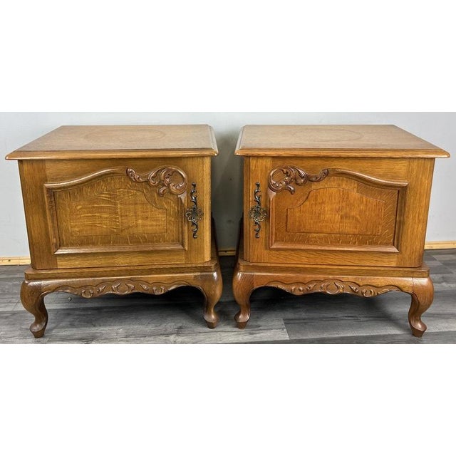 This attractive pair of Vintage French Louis style bedside tables display classic proportions, panelled cabinet doors, and...