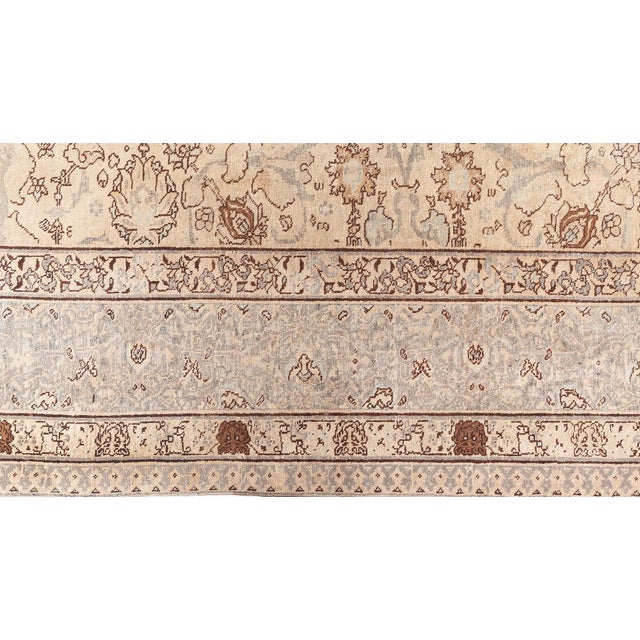 This circa-1880 antique Persian Tabriz rug features an all-over design of floral abstractions and arabesques outlined in...