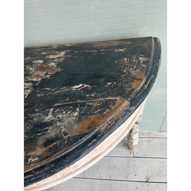 Beautiful Italian demi-lune console table with three turned painted legs in cream patina, and table in a charcoal gray....