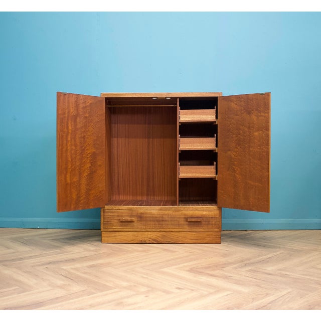 Double doors open to hanging space on the left, with a fitted bank of small drawers and shelving to the right. Large...
