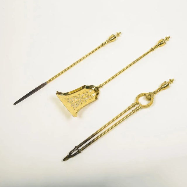 Comprising a stoker, shovel, and tongs, each surmounted with an urn-form finial.