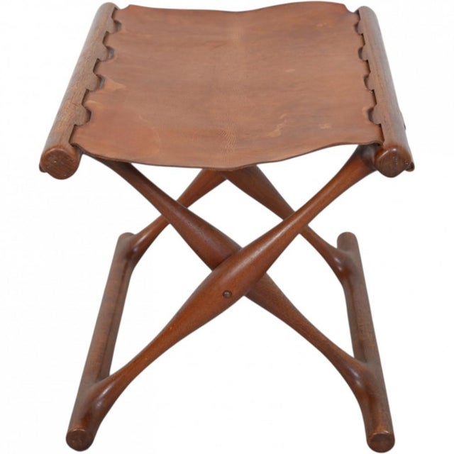 Poul Hundevad Guldhøjstolen with a frame of teak and seat of natural leather. The stool is from the 1960s and appears with...