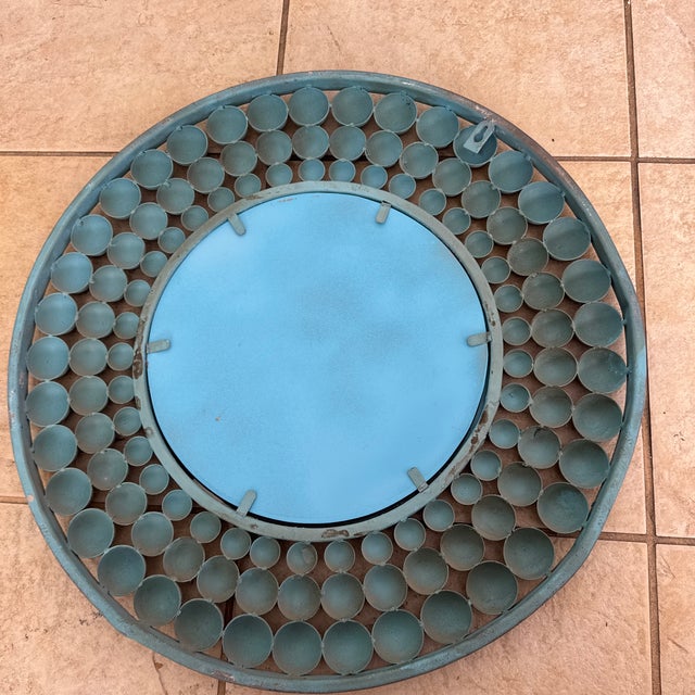 A one-of-a-kind statement mirror featuring concentric rings of hand-turned wooden spheres in a weathered robin’s-egg blue,...