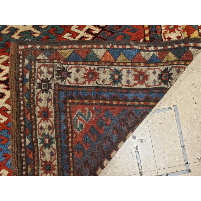 The Rust field scattered with minor stylized flower heads, hooked panels and minute cross-motifs around a column of ivory...