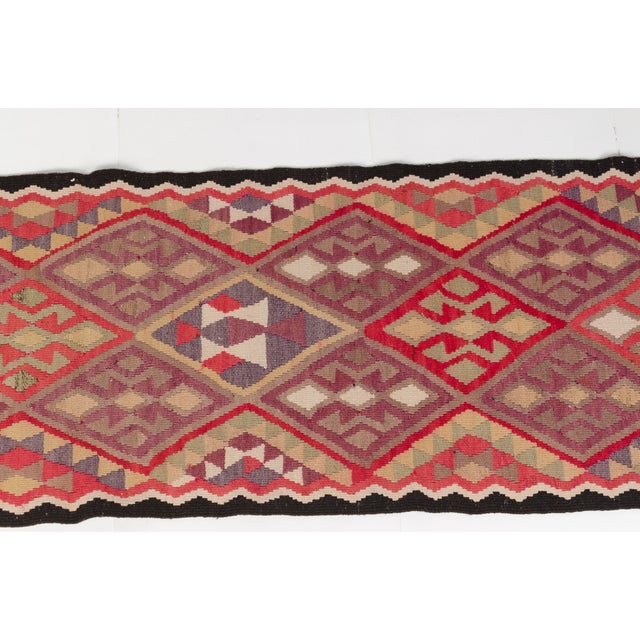 This is a vintage Turkish Oushak rug from the Mid 20th Century. The piece was hand-knotted.