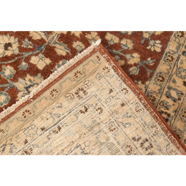 An early 20th century Persian Tabriz rug, the light brown with an exuberant trellis in beiges and blues of palmettes and...