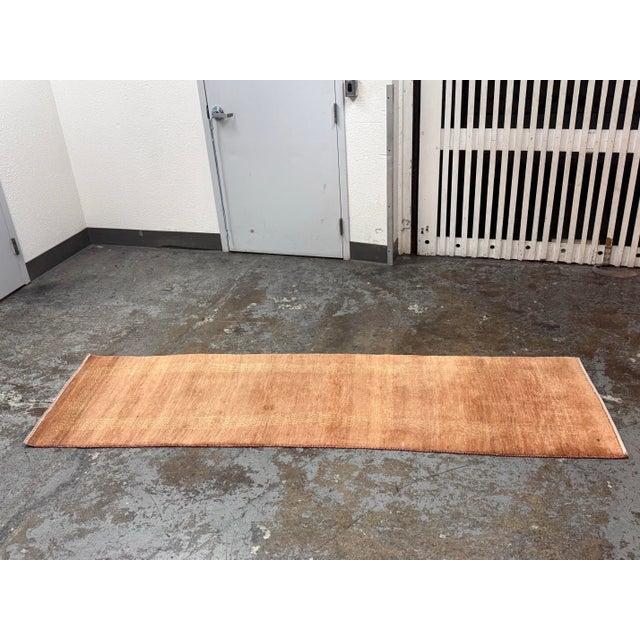 Design Plus Gallery presents a 2ft6in × 8ft8in Vintage Hand Knotted Wool Runner. This wool runner has rust, camel, and...