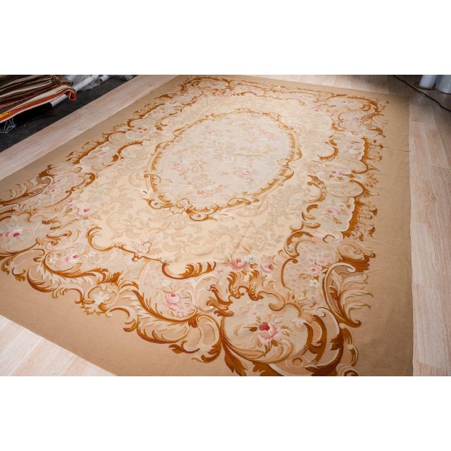 Vintage French style Aubusson in the workshop's 'Royale' design. An oval medallion filled with sprays of pink roses sits...