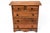 A small antique pine chest of drawers with two short top drawers, three graduated long drawers, dark stained turned wood...