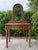 A charming vintage wicker and rattan vanity featuring an oval swivel mirror, single storage drawer, and beautifully...