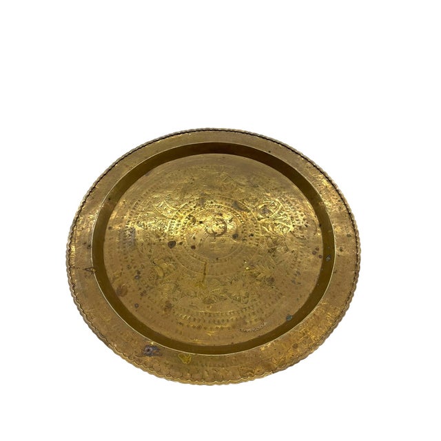 This large decorative brass-toned tray features an intricately engraved surface with layered geometric borders, floral...