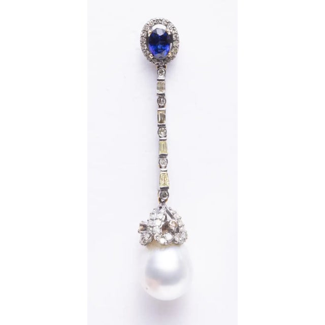 A stunning pair of dangle earrings with a faceted, oval sapphire on the post surrounded by round, pave` set diamonds....