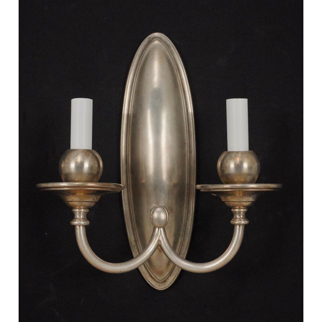Antique Traditional style Bradley & Hubbard silvered brass wall sconces with two arms. They are in good condition with...