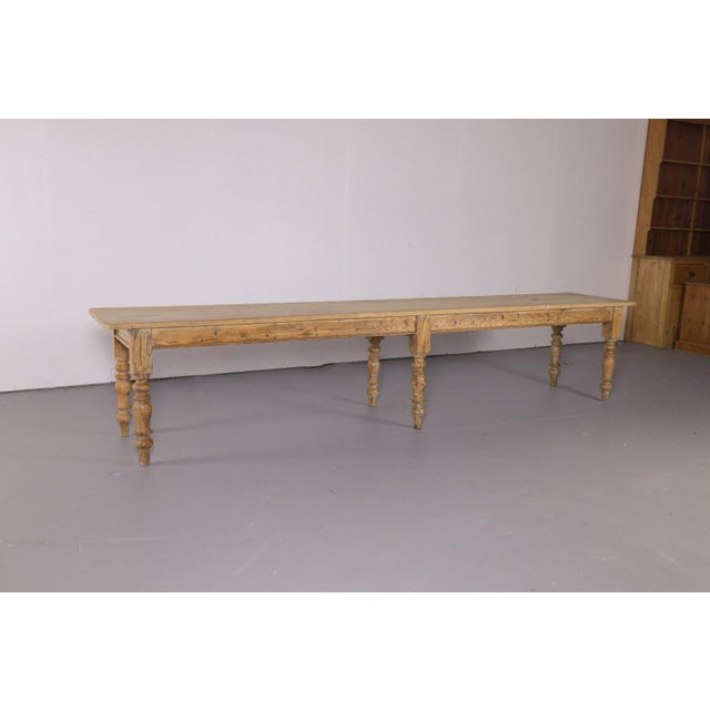 An exceptional oversized antique pine farmhouse table measuring an impressive 12.5 feet long. The long, narrow proportions...