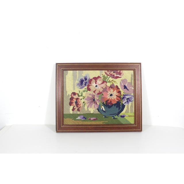 This is a colourful floral still life needlepoint in a wood frame. The wood frame has two thin gold lines and no glass....