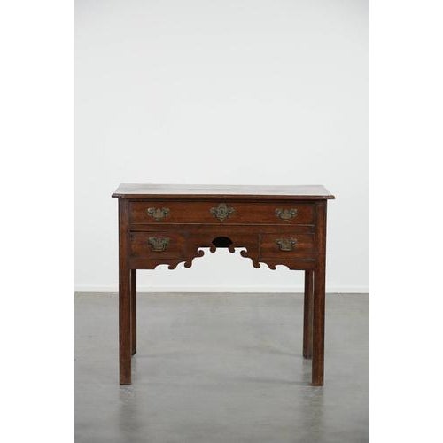 We are offering this beautiful antique English lowboy/side table made of oak from the 18th century with elegant details....