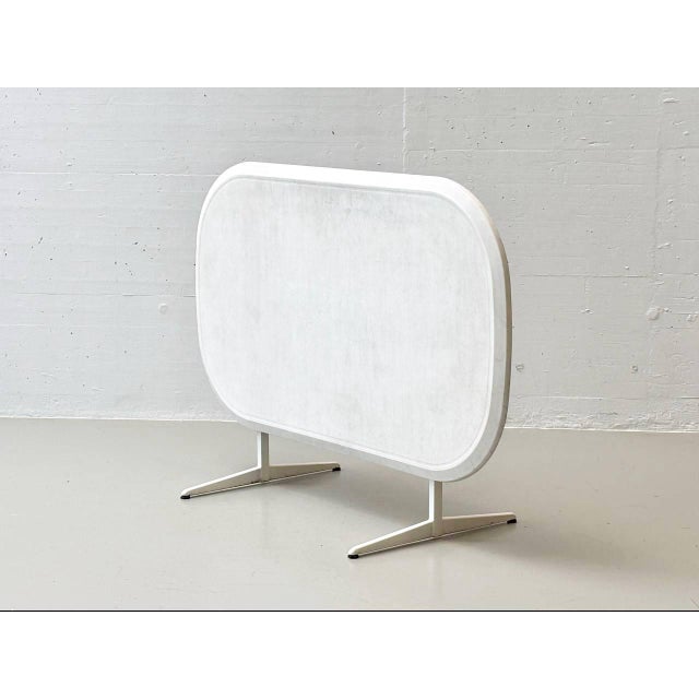 The piece of furniture shown is a folding garden table with a central pedestal and t-shaped base. The tabletop has a...