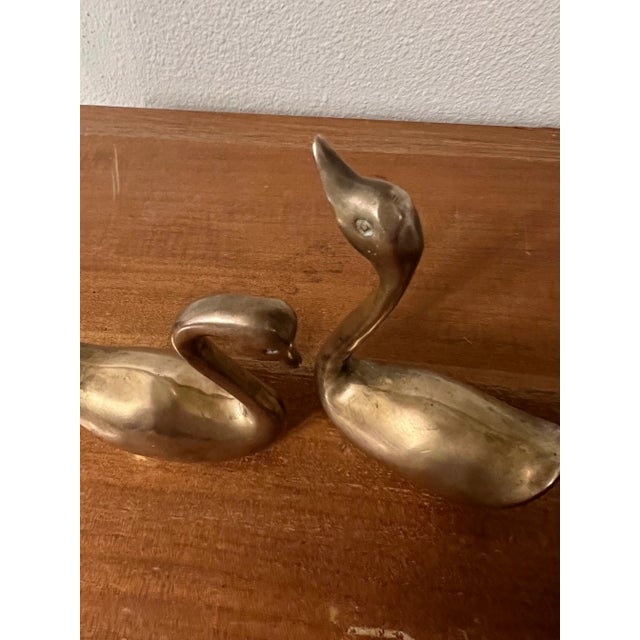 This is a pair of mid-century brass swan figurines. MEASUREMENTS Swan 1 5.25 in x 3.5 in x 1.75 in Swan 2 4 in x 3.25 in x...