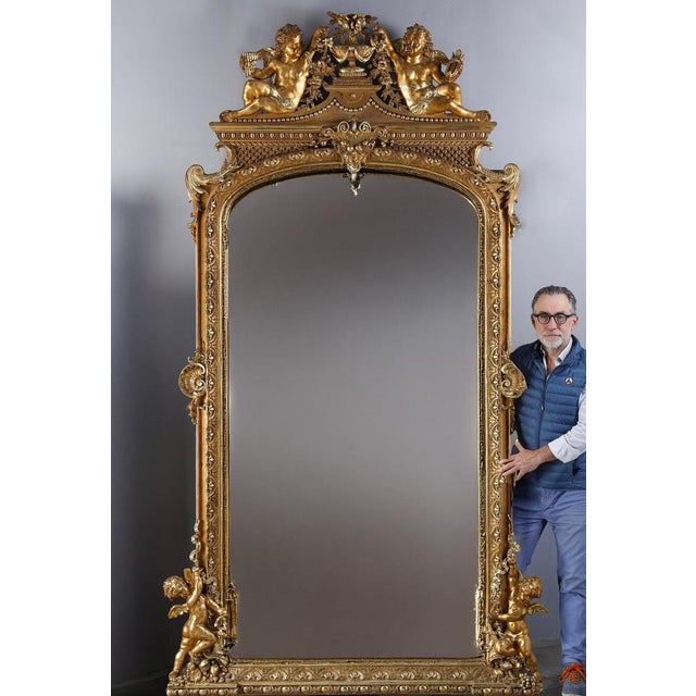 Majestic mirror featuring a richly carved and gilded frame decorated with scrolls, pearl friezes, acanthus leaves and...