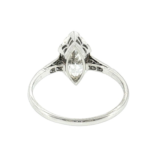 An early 20th-century platinum engagement ring featuring a marquise-cut diamond. The primary stone weighs 1.77 carats,...