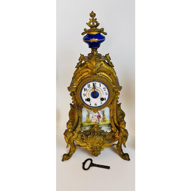 French Sevres-style porcelain and ormolu click garniture set [3 PCs] Set features a central mantel clock & 2 matching side...
