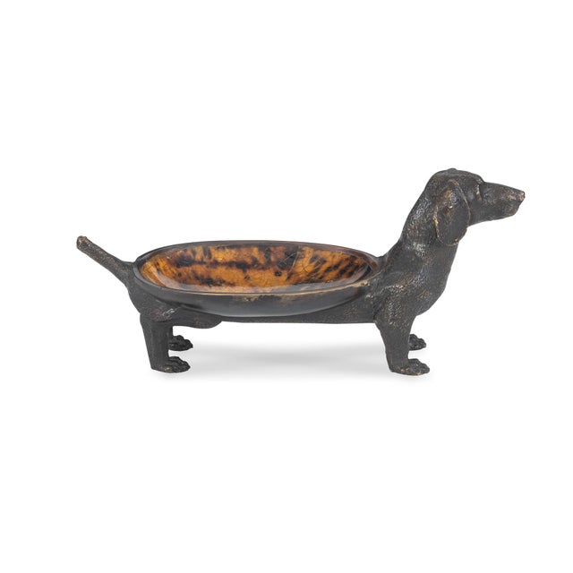 Cast brass dachshund dish finished in Barcelona Bronze. Tiger penshell bowl on the dog's back acts as a catchall tray for...