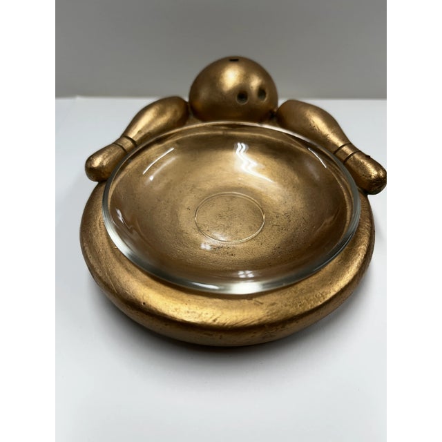 Marvelous 1950s bowling ashtray, gold toned, with bowling ball and two pins. Removable glass liner for ashes. Kitsch.