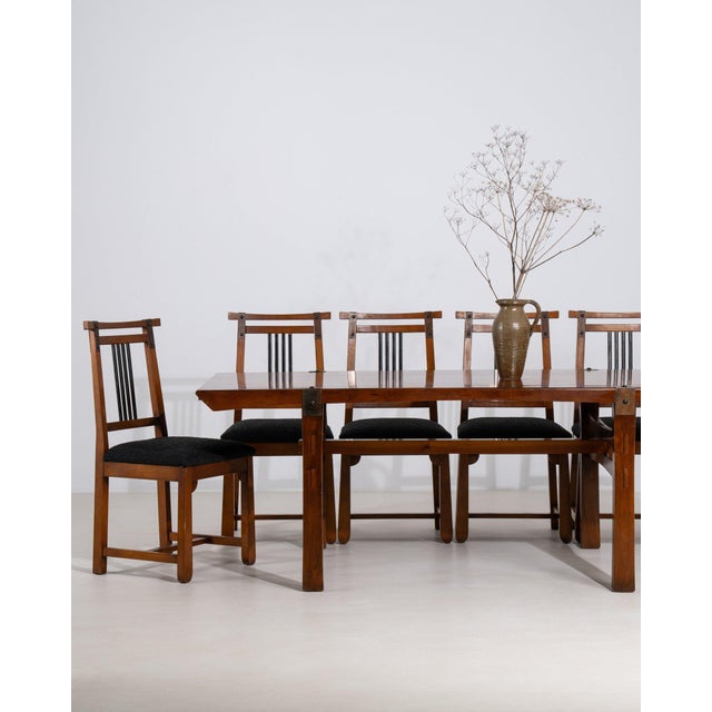 This set of dining chairs with table makes its impression through dark wood, black upholstered seats. The piece dates to...