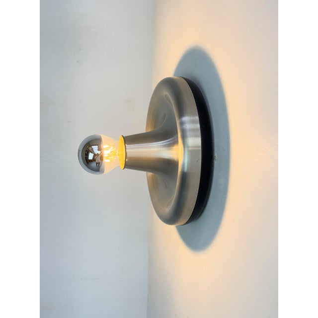 Compact space-age wall or ceiling light made of brushed aluminum. with a mirrored bulb, the lamp provides beautiful light....
