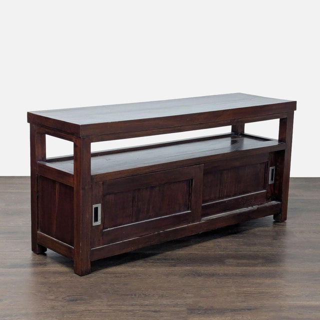 This cabinet features a rich dark wood finish, a spacious top, and an open shelf for display or storage. It has two...