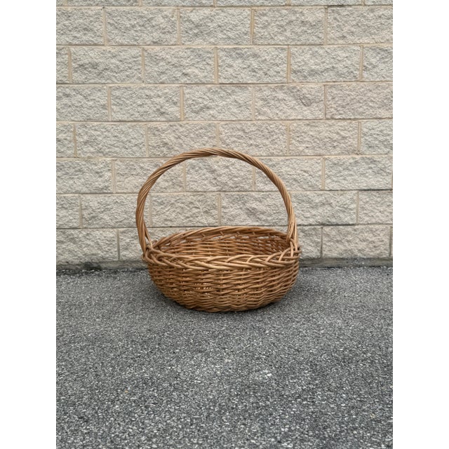 Exceptional oversized vintage wicker gathering basket, handwoven with a substantial sculptural handle and beautifully aged...