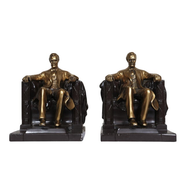 A pair of "Lincoln in the Chair" brass bookends, made by the Philadelphia Manufacturing Company. A polished brass Lincoln...