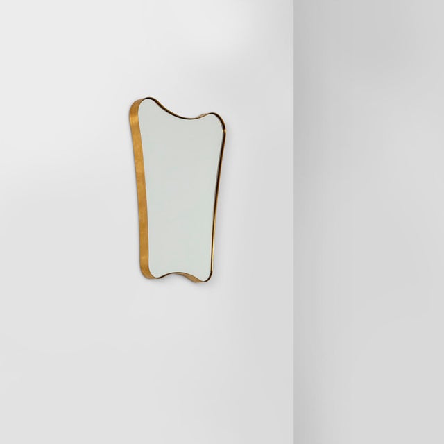 Inspired by a classic mid-century shape, this mirror features a sleek brass frame. Perfect for wall hanging in hallways or...