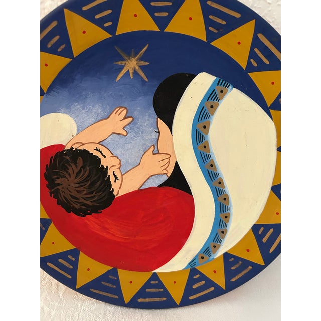 Lovely redware decorative plate featuring a vibrant hand-painted motif of Madonna and child. Loop on back should desire to...