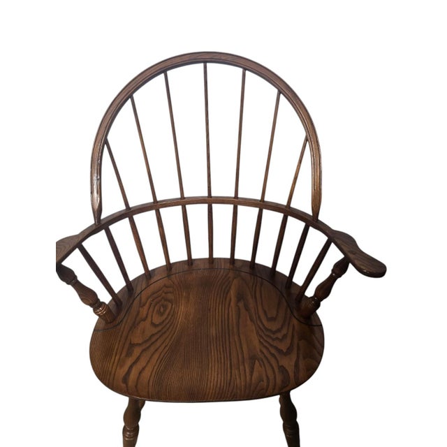 Generously sized vintage Windsor-style armchair featuring a distinctive double-bow spindle back, continuous curved arm...