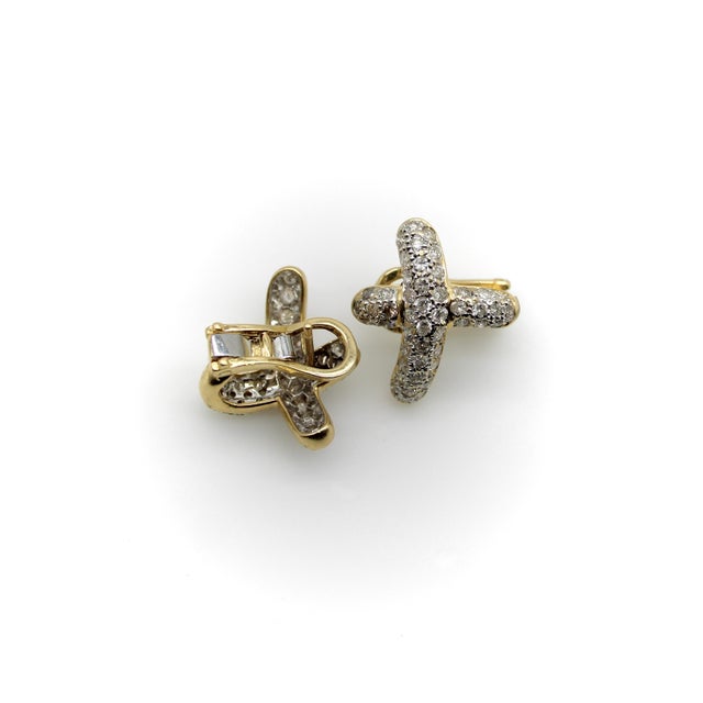 These 14k gold diamond earrings have a calligraphic X as a motif. The curve of the earring swoops up, and can be placed to...