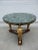 A gorgeous Empire style mahogany and faux marble top gueridon table supported by three gilded female caryatids (female...
