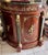 Elegant and highly decorative French Empire style demilune bar cabinet featuring a stunning green marble top and richly...