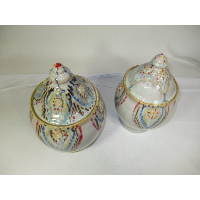 A set of 2 studio pottery slip glaze covered jars. These gloss finish jars are taupe in color with a flame slip pattern in...