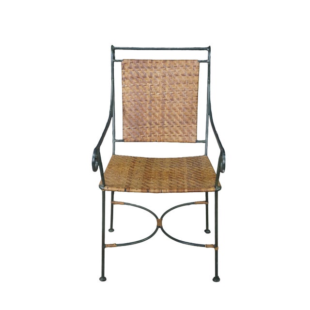 Pair of mid-century modern iron and woven wicker patio dining chairs. Displaying a striking minimalist, sculptural...